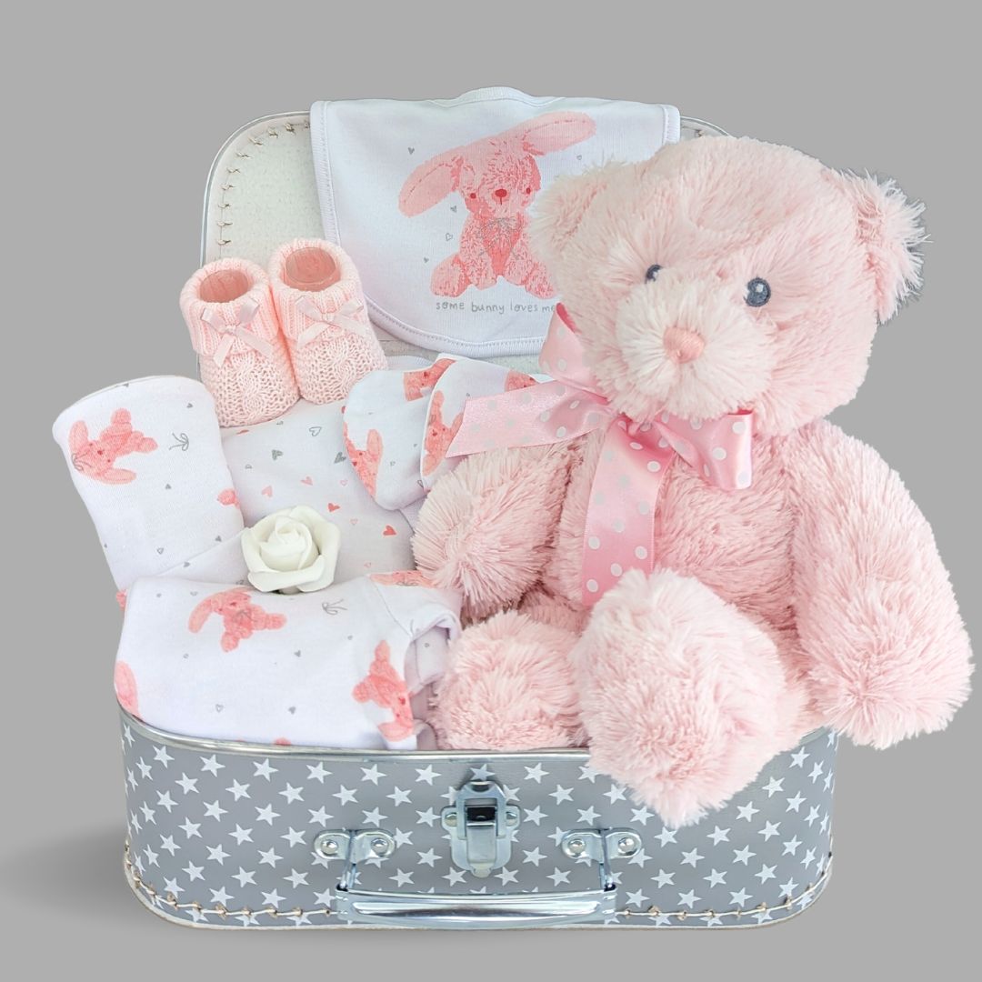 Stunning new baby girl gift hamper. Presented in a luggage suitcase trunk with gift wrapping. Includes large pink teddy bear and pink bunny clothing set.