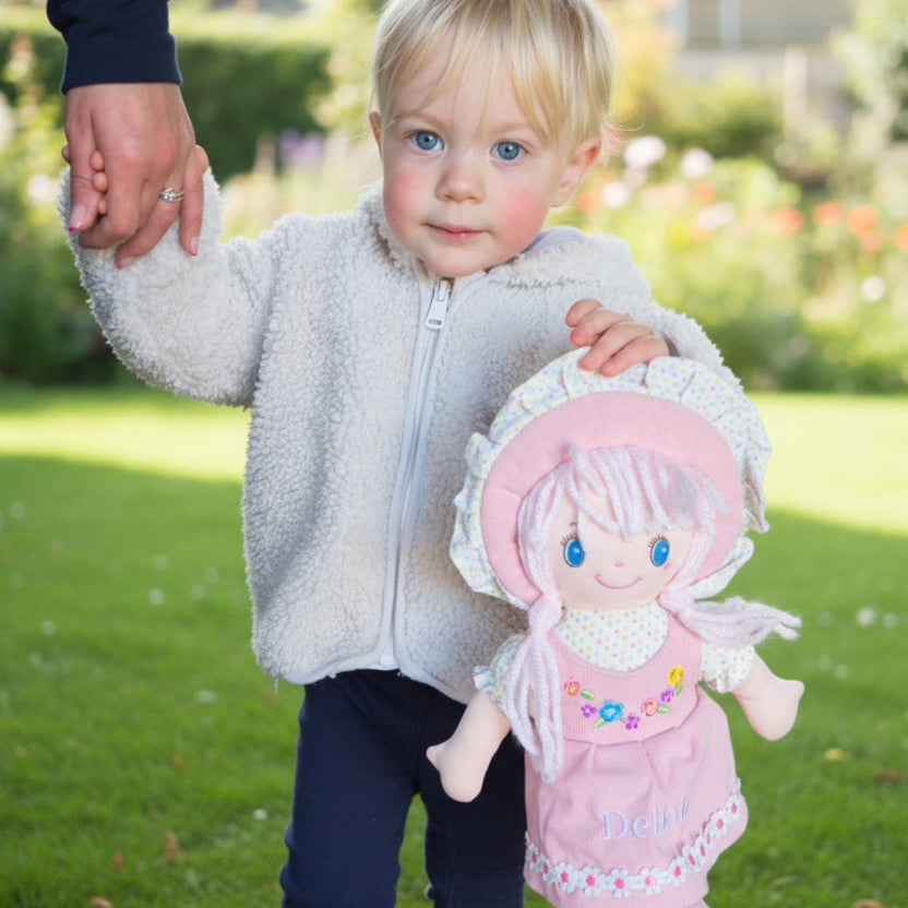 A pink doll which has a dress and can be personalised.