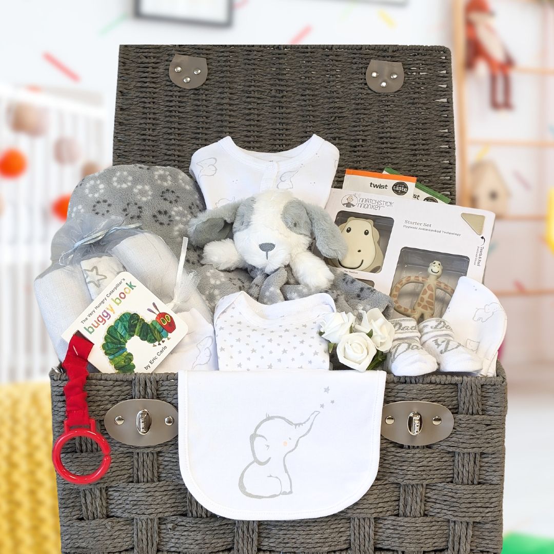 Large baby hamper with clothing, book, teething, blanket and soft toy.