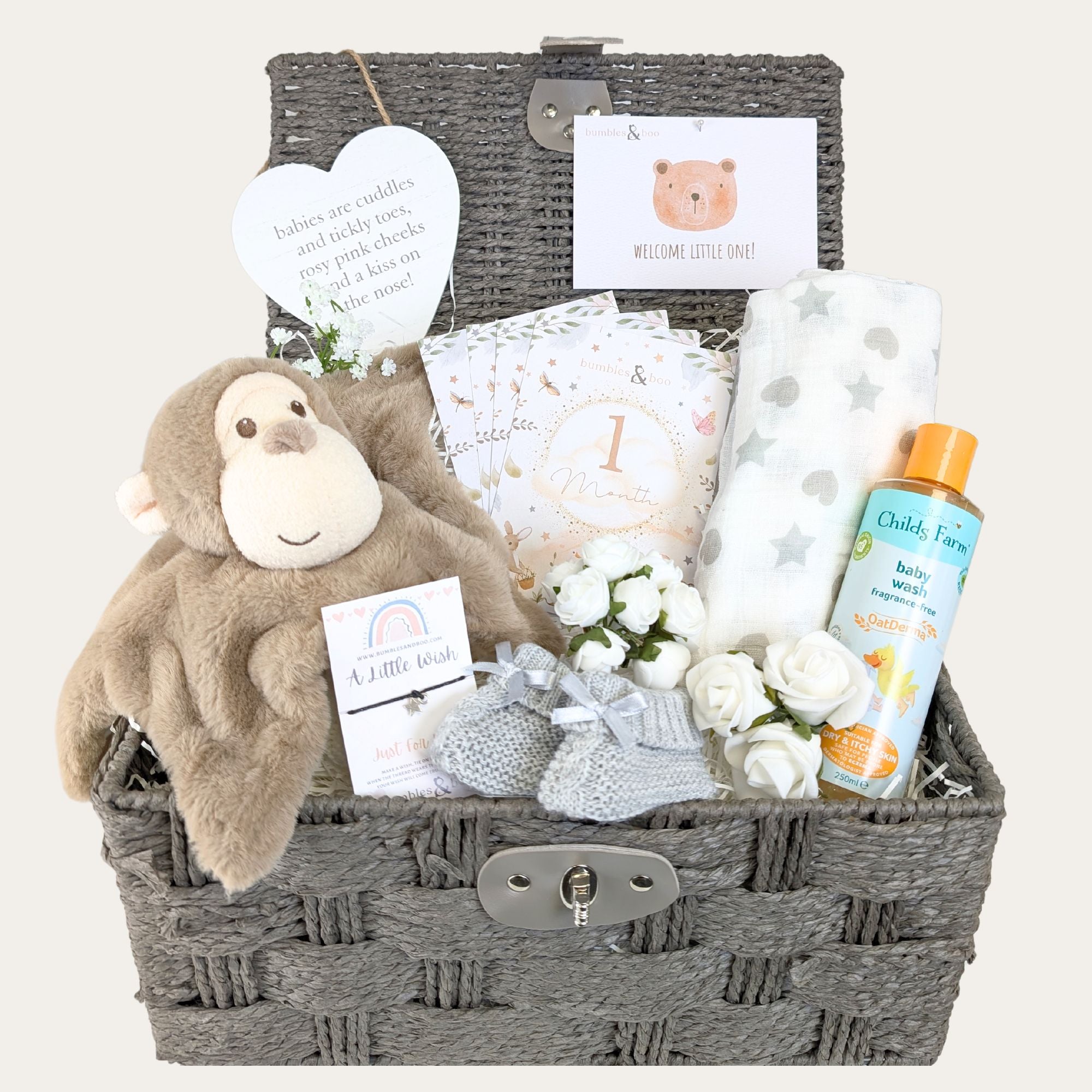 Baby hamper basket packed with gifts for a newborn with monkey comforter by bumbles and boo.