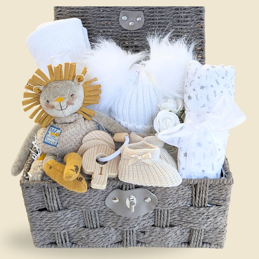 Beautiful unisex baby hamper gift with a lovely lion theme. Includes organic lion soft toy, white cellular blanket, baby booties, cotton muslin, teething keys. Presented in a hamper basket.