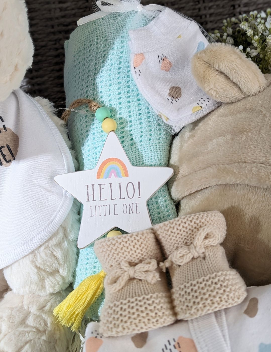 Large teddy bear baby basket with cuddly teddy bear, baby bath robe, muslin squares, baby booties and also a gift for mum. Presented in an eco rope basket.