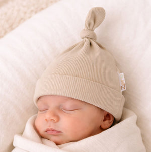 Beige ribbed baby hat with a little knot