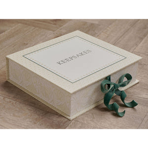 Closed cream patterned keepsake box with ‘KEEPSAKES’ on the lid and green ribbon ties.