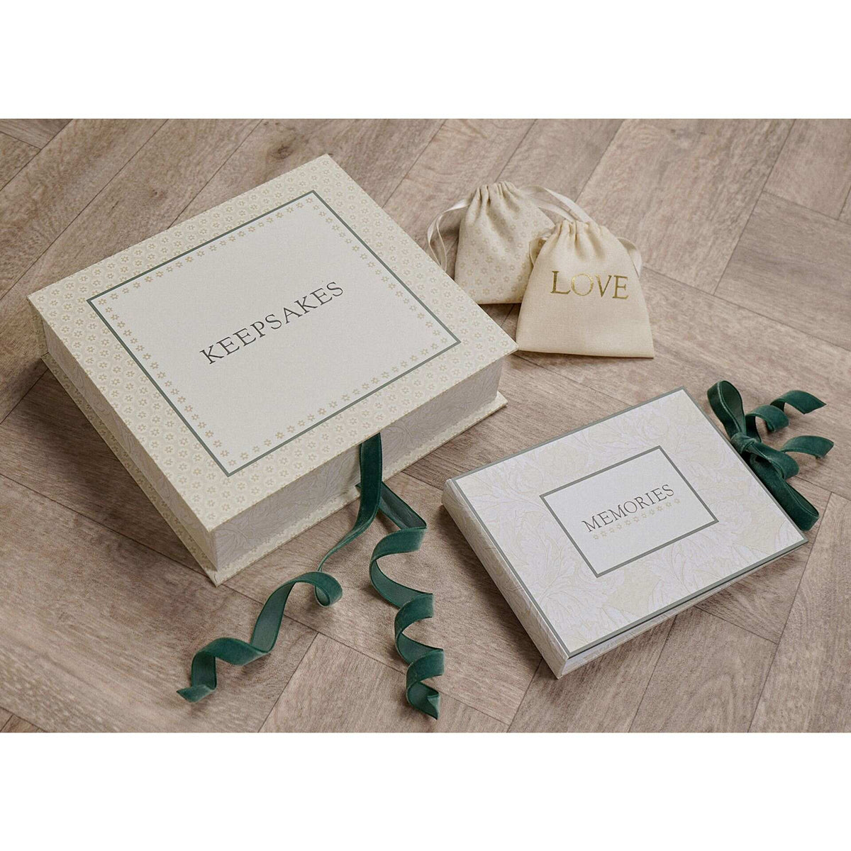 Baby keepsake box styled with a ‘LOVE’ pouch and matching ‘MEMORIES’ item on a wooden surface.