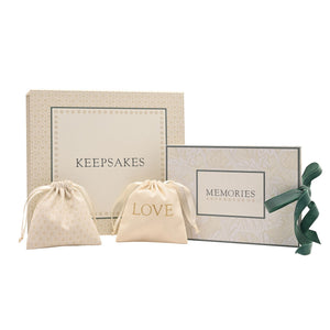Neutral keepsake box, two drawstring pouches and a ribbon-tied ‘MEMORIES’ item against white.
