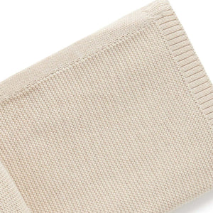 Closeup of beige organic ribbed edging on baby blanket