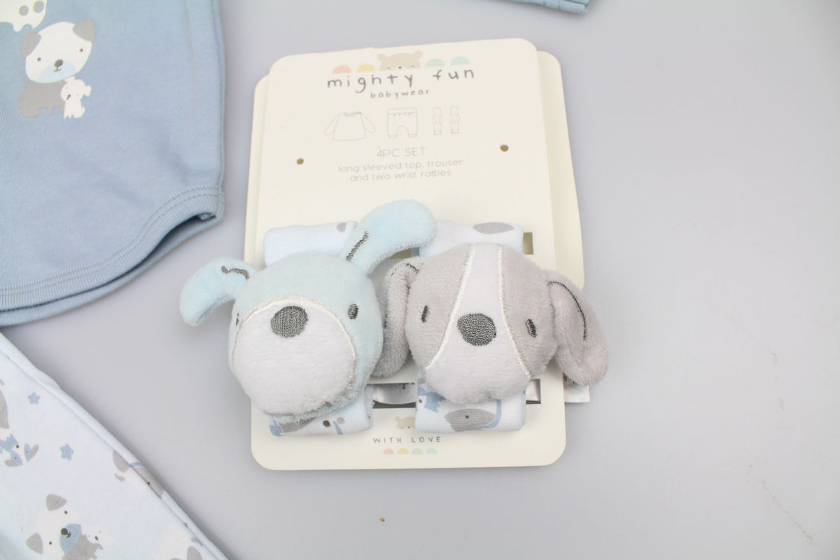 Close-up of blue and grey puppy wrist rattles with embroidered faces, attached to their display card.