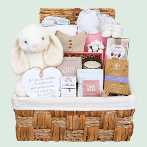 Baby shower gifts hamper with white bunny soft toy and gifts for mum packed in a basket by Bumbles and Boo.