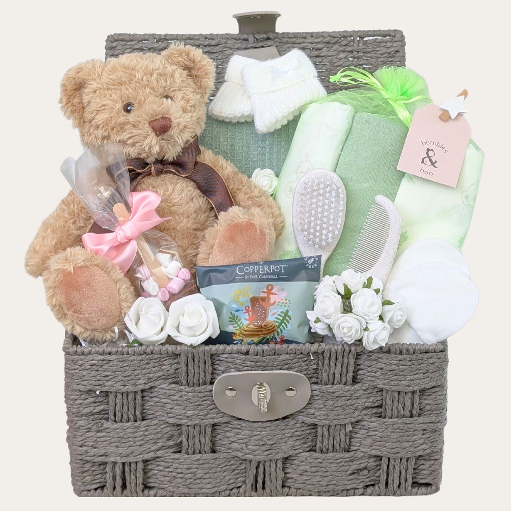 Green and Sage themed baby shower gifts hamper with presents for mum and baby in a brown wicker basket - including a traditional brown teddy bear.