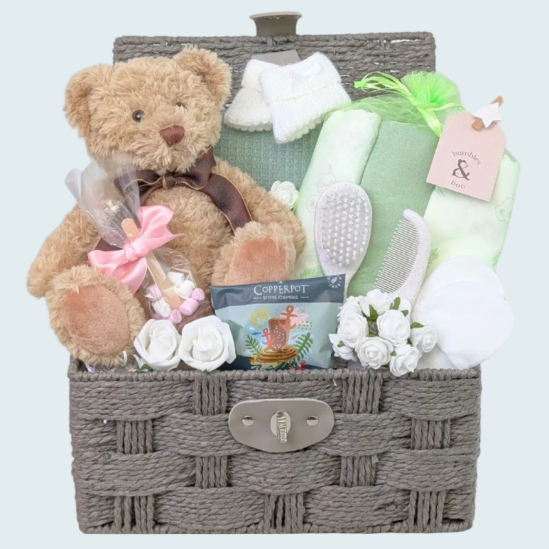 Green and Sage themed baby shower gifts hamper with presents for mum and baby in a brown wicker basket - including a traditional brown teddy bear.