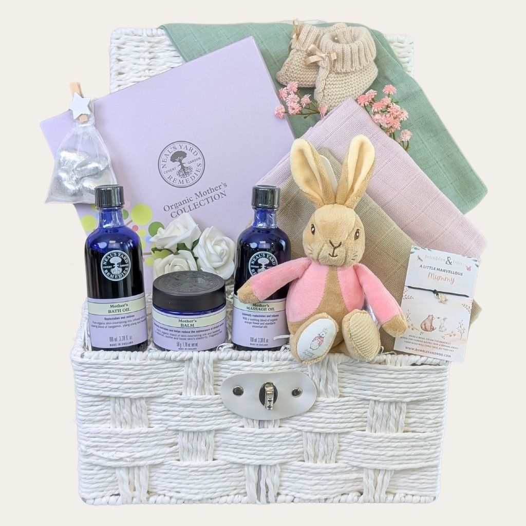 Baby shower gifts hamper with organic Neals Yard and pink presents for mum to be in a white basket