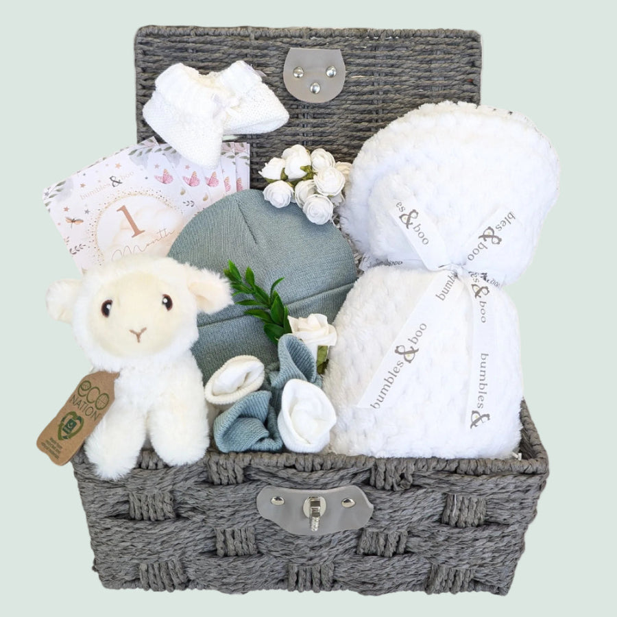 Baby shower gifts hamper with white blanket and lamb soft toy packed in a basket by Bumbles & Boo.