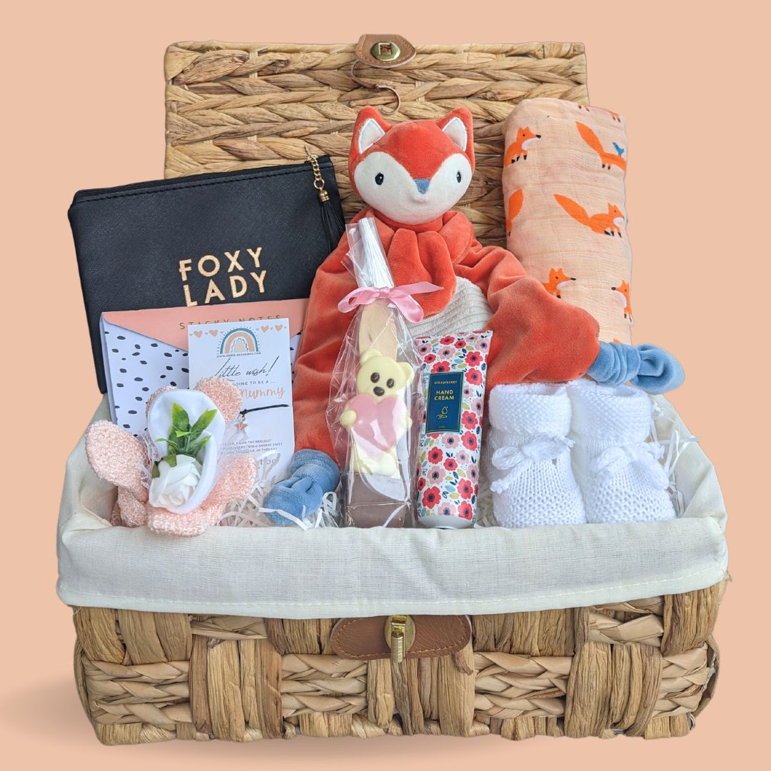 Baby shower hamper with fox theme gifts in a wicket basket.