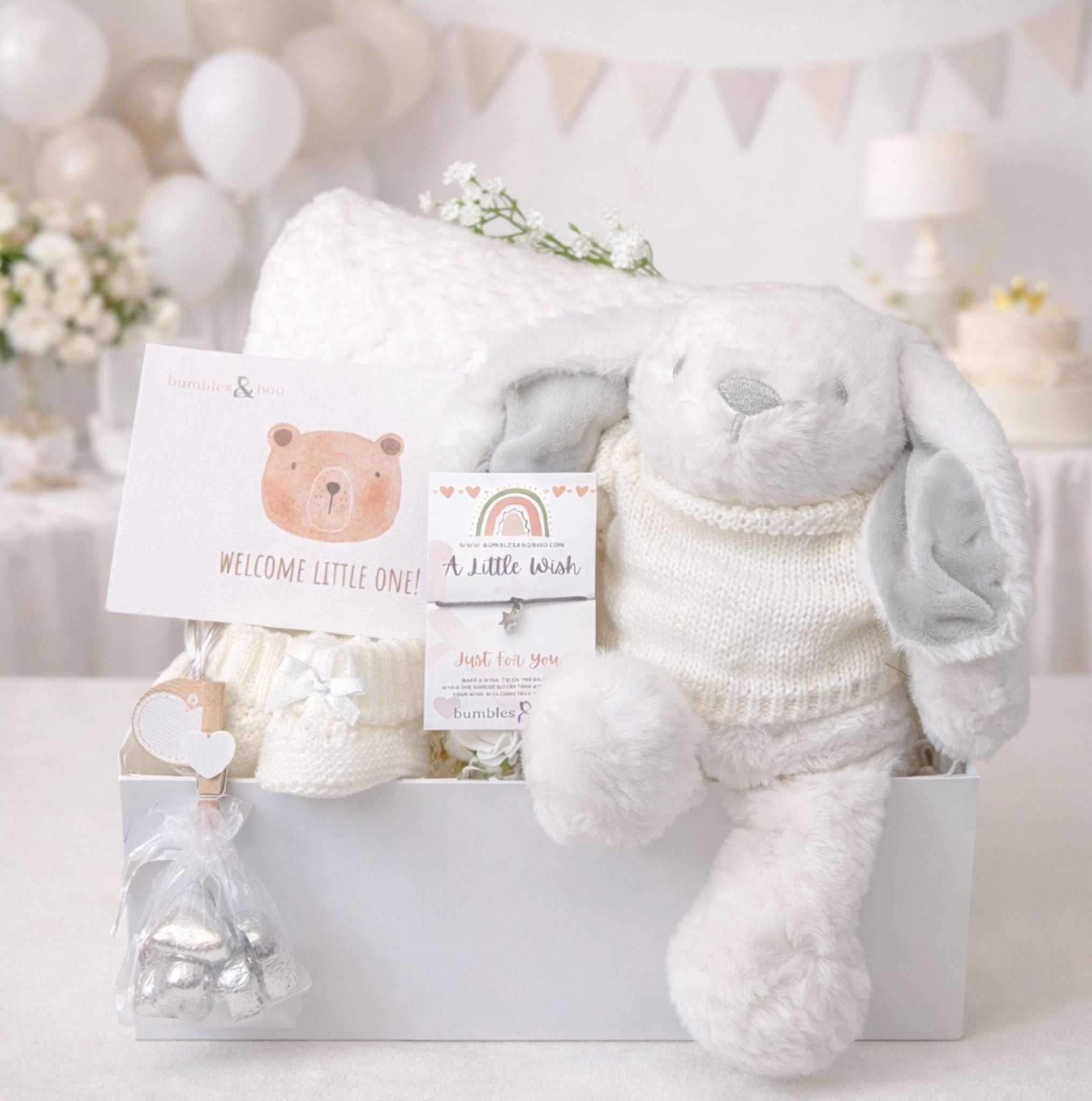 A baby shower hamper gifts box with a white bunny soft toy and baby blanket.