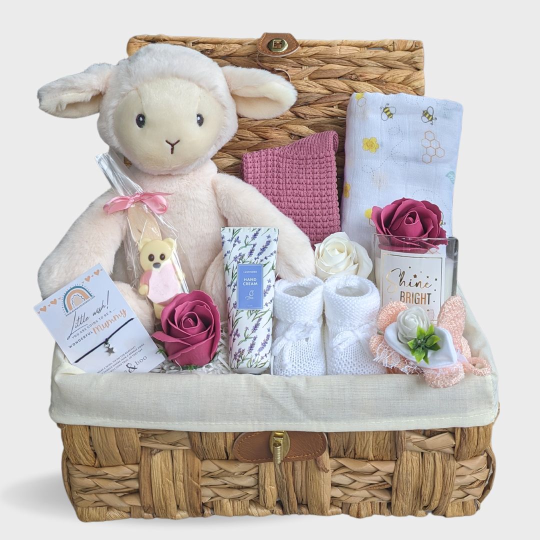 Baby shower hamper with gifts including white lamb toy & pink soap roses.