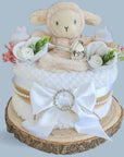 Baby shower gifts nappy cake in white with lamb topper.