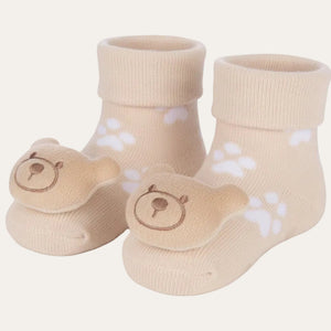 Beige baby teddy rattle socks with soft knitted fabric and plush bear face detail