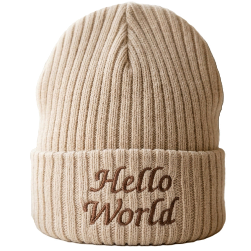 A beige ribbed knit beanie hat with the words 'Hello World' embroidered in brown on the front cuff, shown against a plain white background.