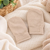 Pair of knit beige cotton mittens in biscuit colour.