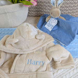 Biscuit baby bath robe with a name embroidered on it.