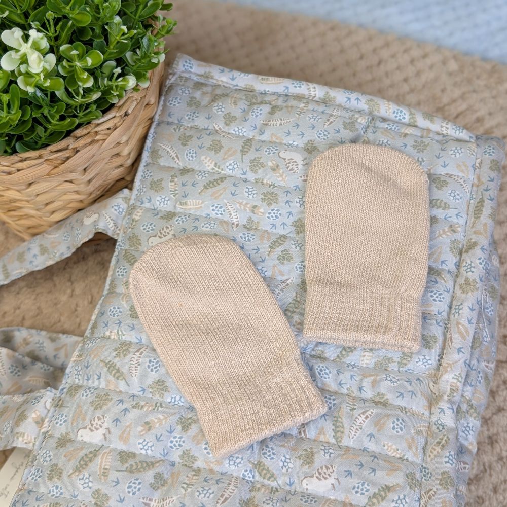 Pair of knit beige cotton mittens in biscuit colour.