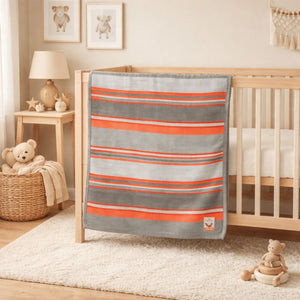 An orange and grey baby blanket in a heavy knit perfect for a nursery