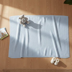 Blue bamboo baby blanket with soft knitted weave laid flat and styled in a neutral nursery