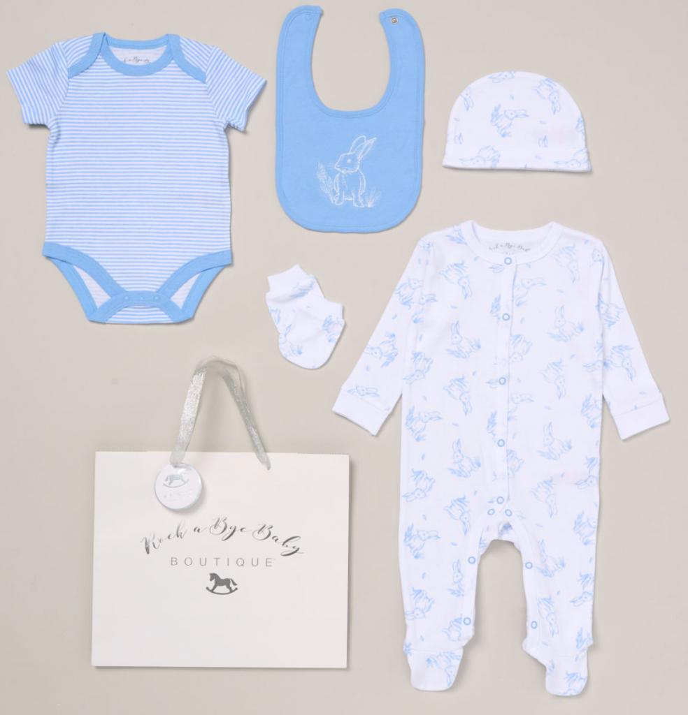 A white and blue baby clothing gift set which has a long sleeve body suit. a short sleeve vest, a blue bib with a white bunny, a hat and a pair of scratch mittens