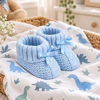 A pair of light blue knitted baby booties with matching ribbon bows