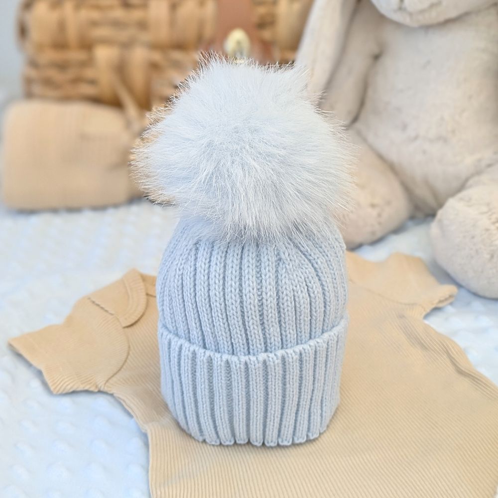 Blue wool knit hat with a blue fluffy pom pom
