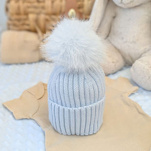 Blue wool knit hat with a blue fluffy pom pom
