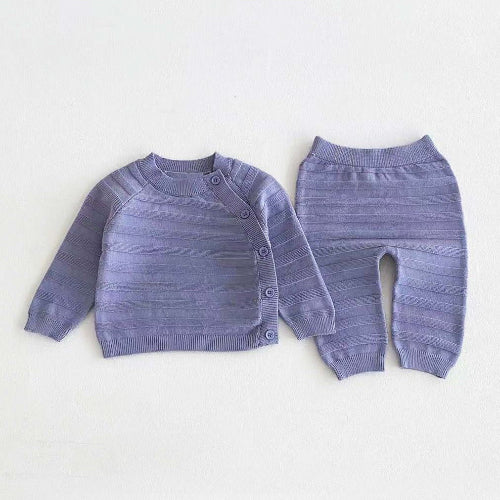 Blue knitted baby clothes set with striped knit top and matching trousers laid flat on white background.