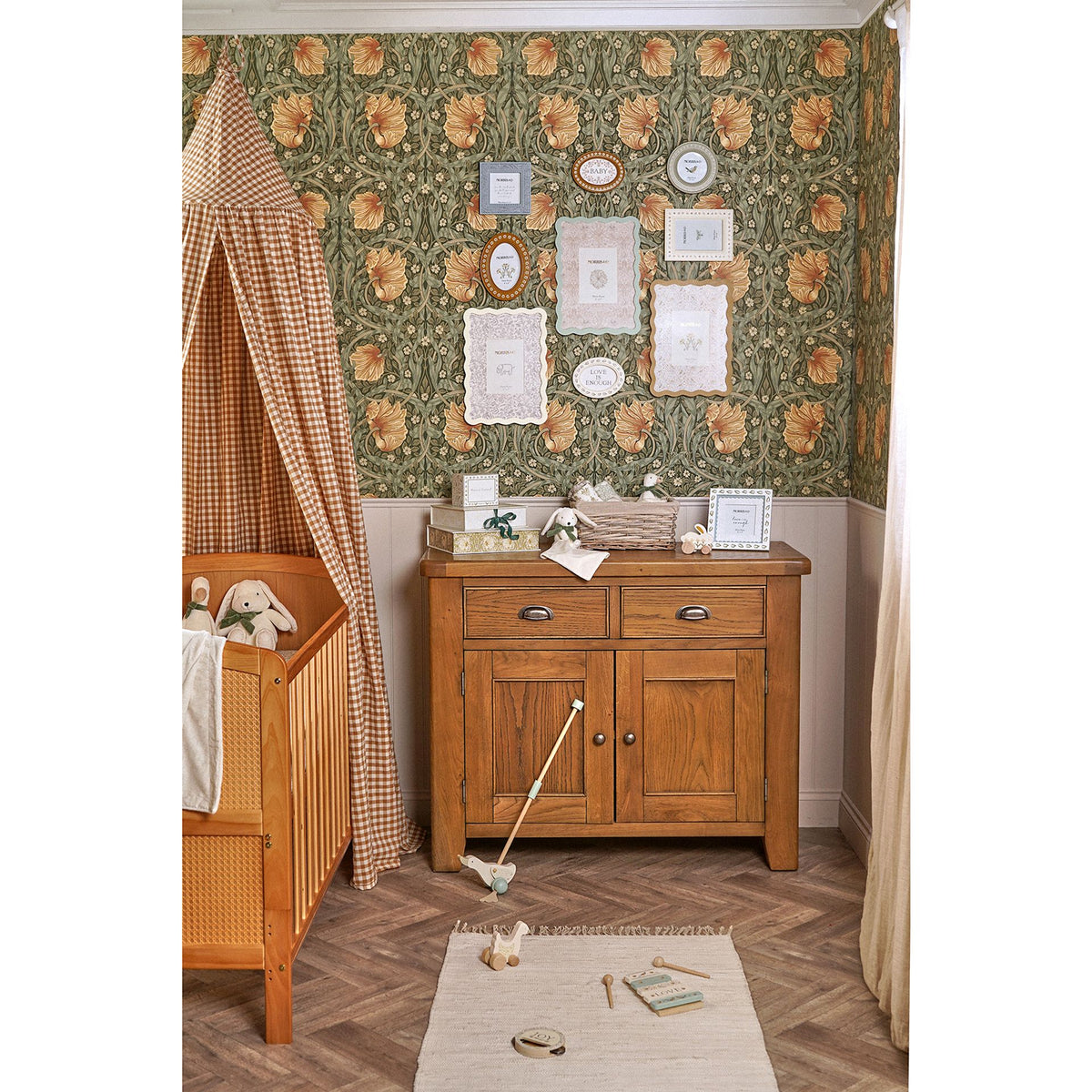 Styled nursery showing a bunny comforter in a basket on a wooden cabinet