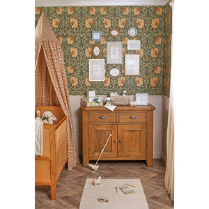 Wide nursery scene with floral wall, wooden cabinet and basket containing bunny comforter