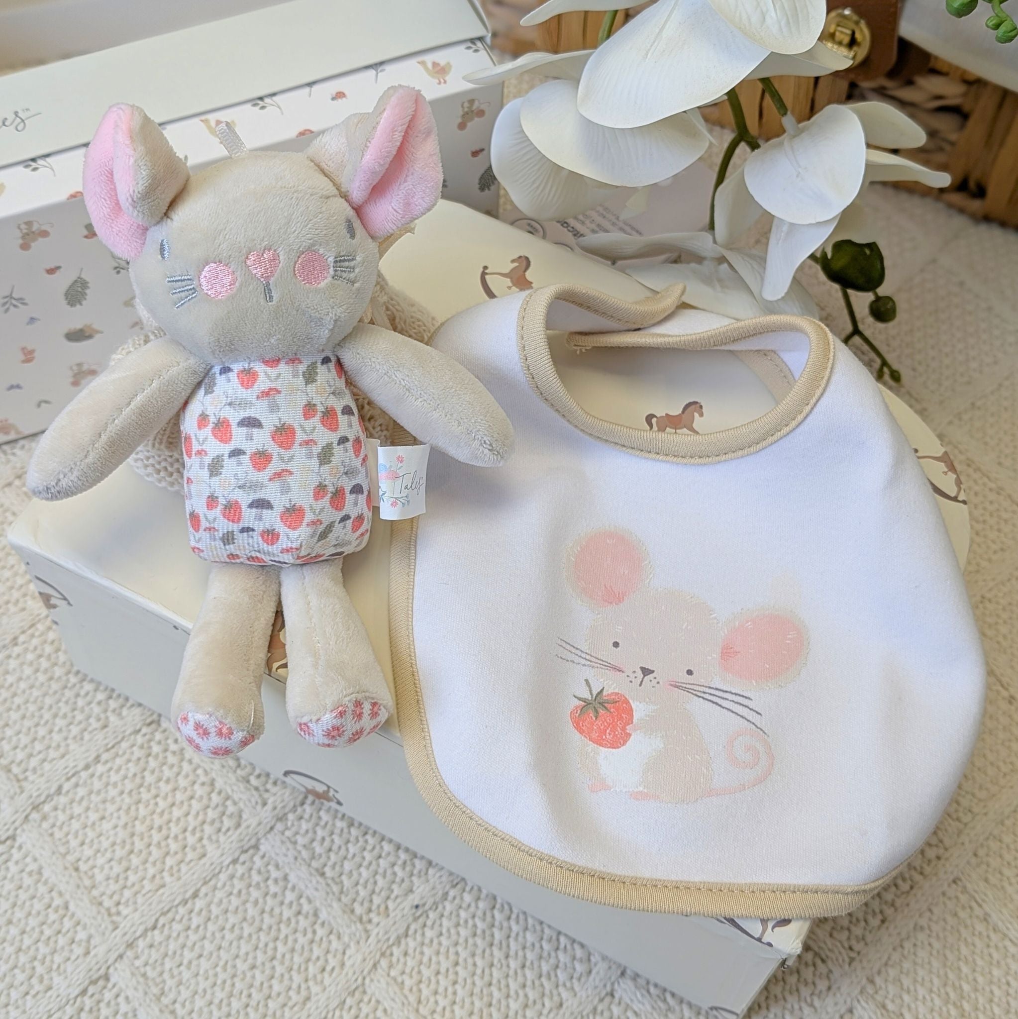 a gift set for a baby girl with bunny soft toy and a baby bib.