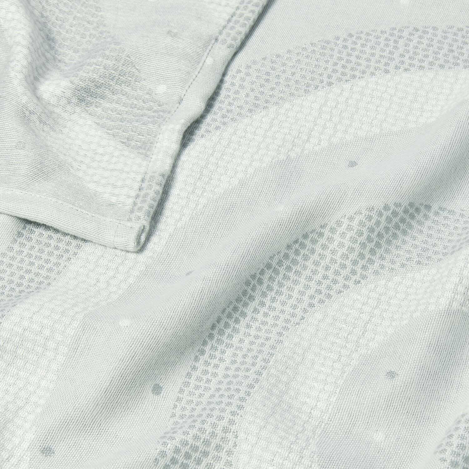 Close-up of cool grey baby blanket fabric showing quilted rainbow pattern and soft texture