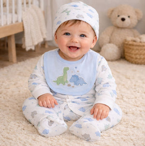 Baby in a nursery setting wearing a bib with dinosaur designs.