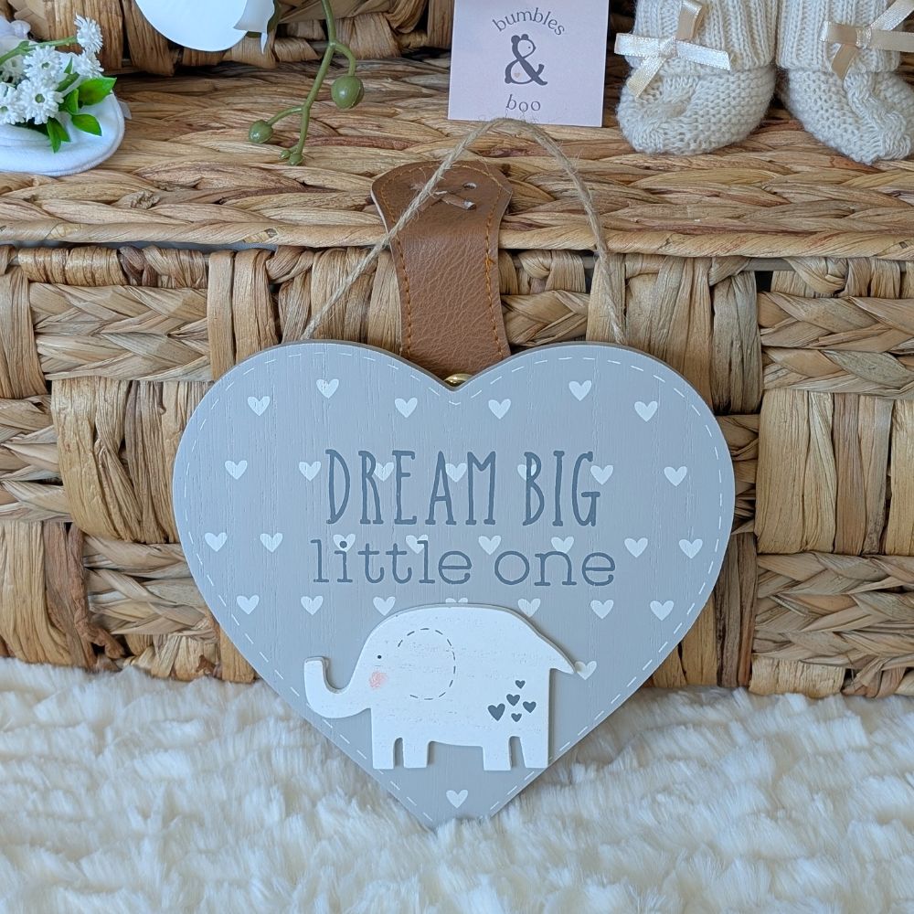 Heart-shaped sign with 'Dream Big little one' text and an elephant illustration.