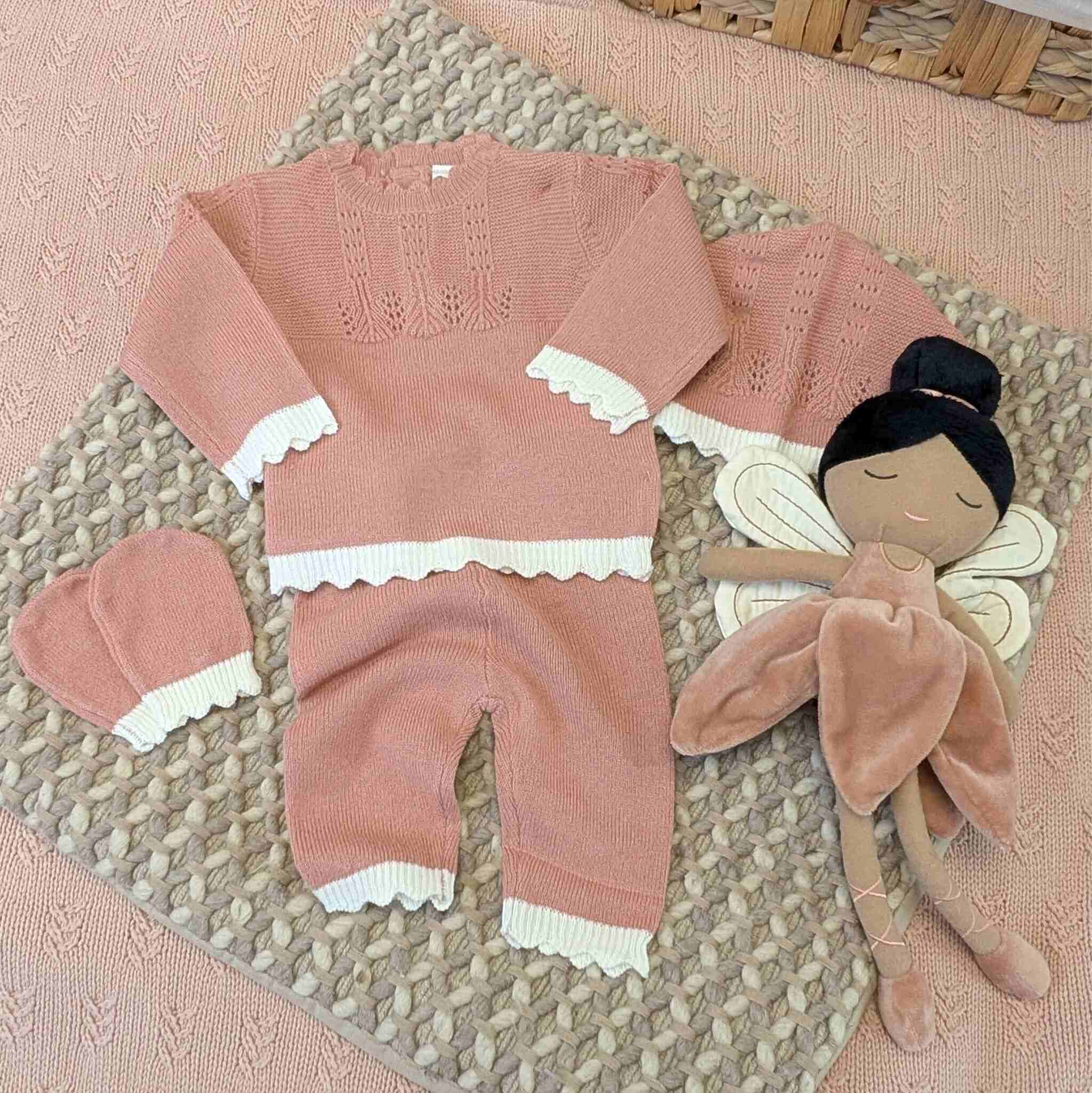 Dusky pink knit baby gift set with white trim.