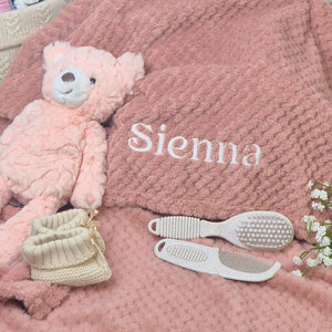Dusky pink waffle baby blanket with personalised name embroidery.