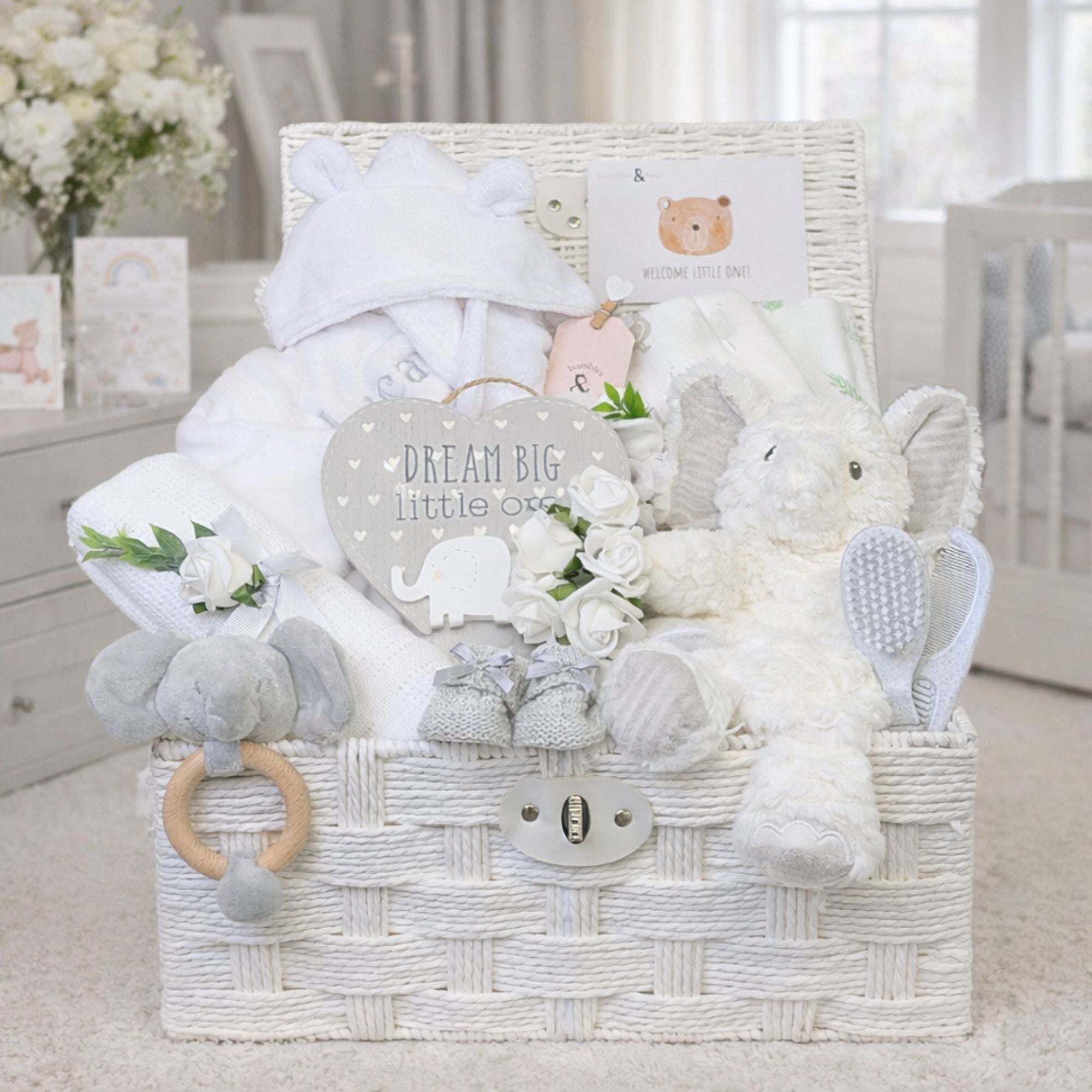 Presents for a new baby arranged in a hamper basket with elephant theme a new baby essentials.