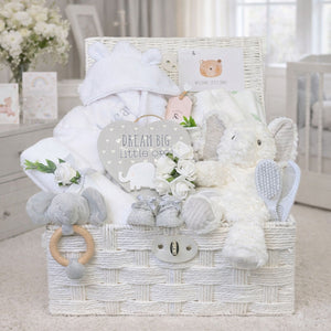 Presents for a new baby arranged in a hamper basket with elephant theme a new baby essentials.