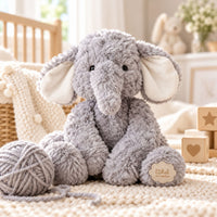 A plush grey elephant toy with cream-colored ears 