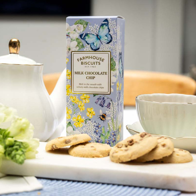 Farmhouse Biscuits Milk Choc Chip Biscuits in an English garden box beside a white teapot and cup