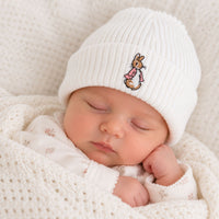 White knitted baby hat with pink embroidered bunny detail close-up