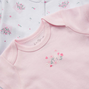 Baby clothing set with floral patterns and says 'little love' on the bib in embroidery