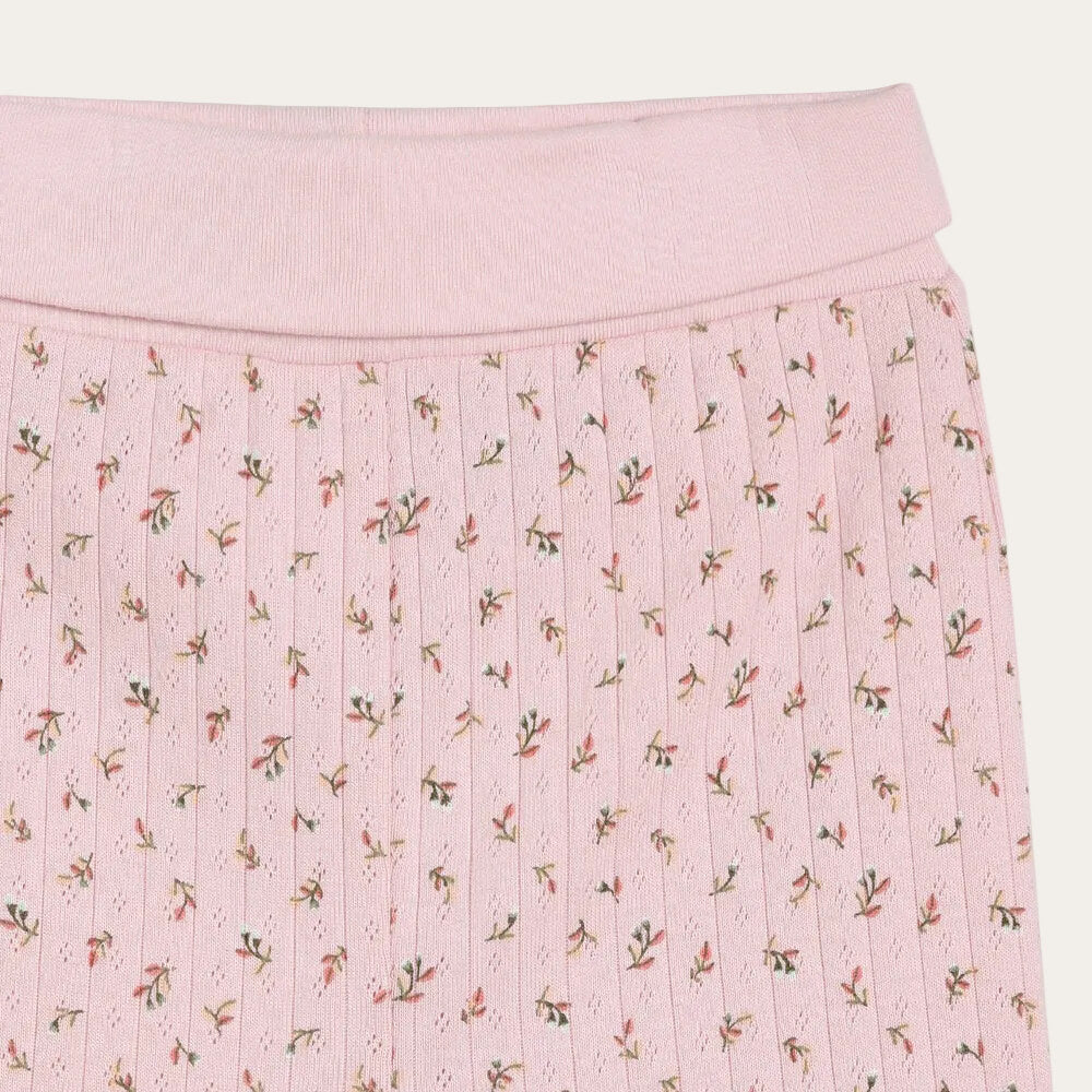 Pink pleated skirt with floral pattern on a white background