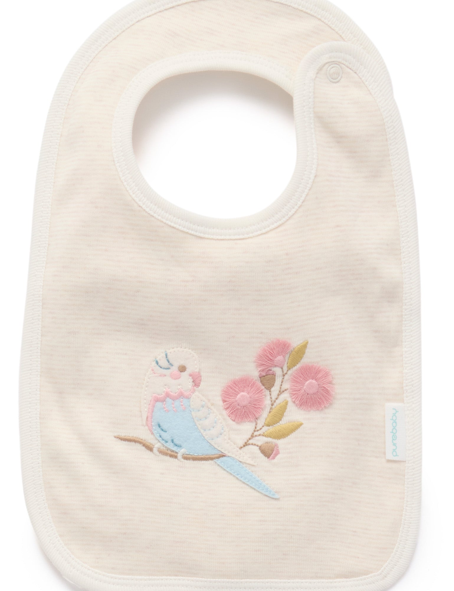Close up of Flower Garden reversible baby bib in organic cotton with embroidered bird detail. Part of baby clothes set.