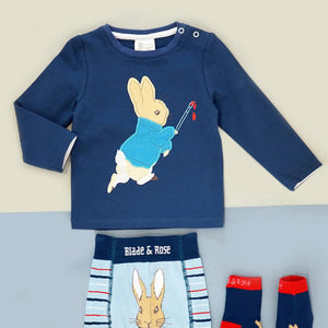 Blue long sleeve Peter Rabbit top holding a paint brush